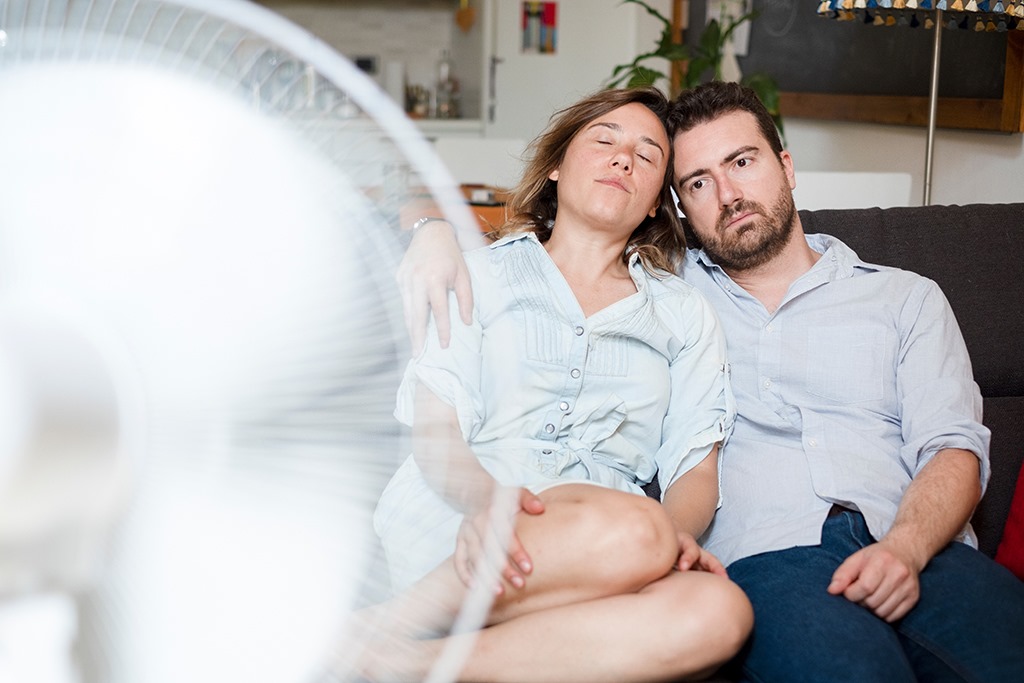 Couple in front of fan searching for air conditioner repair in Bee Cave, Texas.