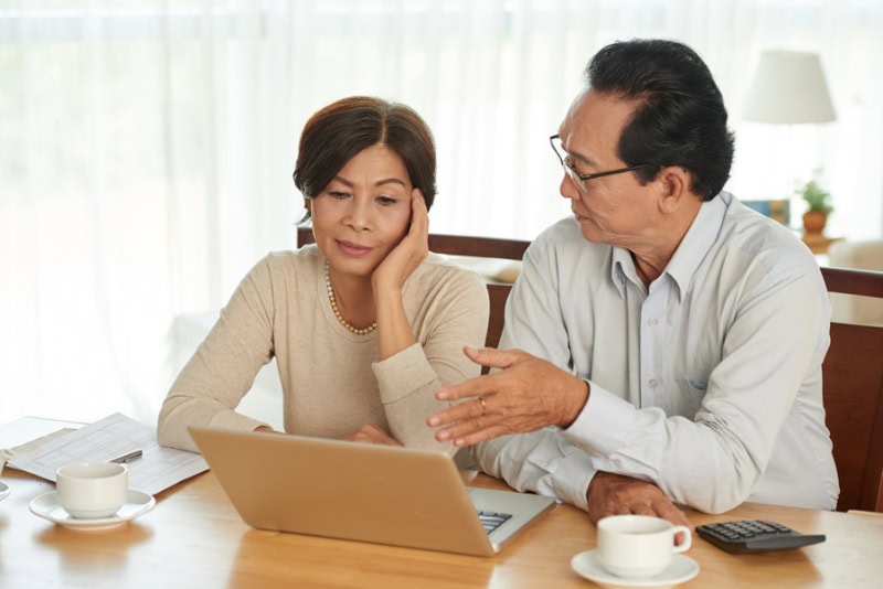 Unhappy senior couple discussing family budget.