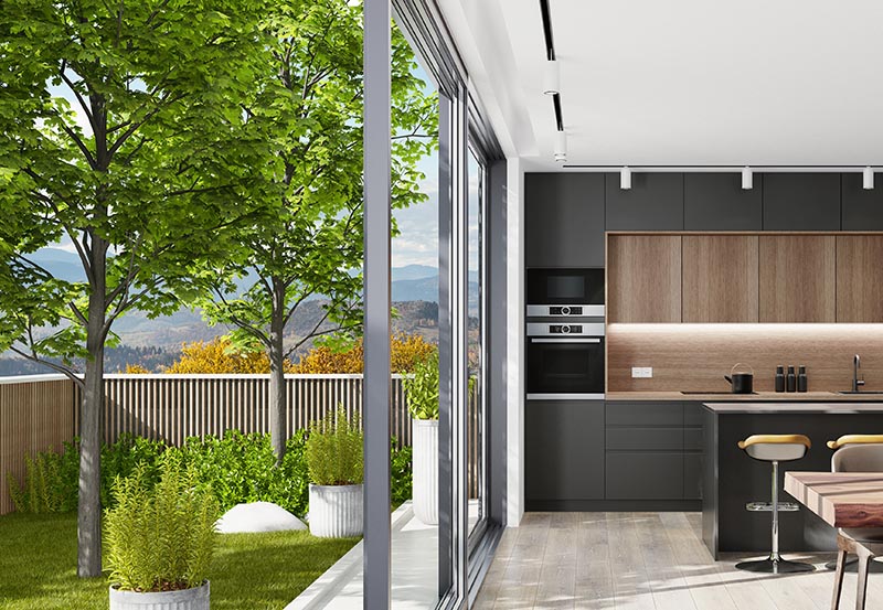 Country modern villa with garden. Matte black kitchen interior with island table and dining table.